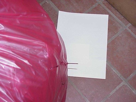 Needle protruding through a soft-sided red waste bag